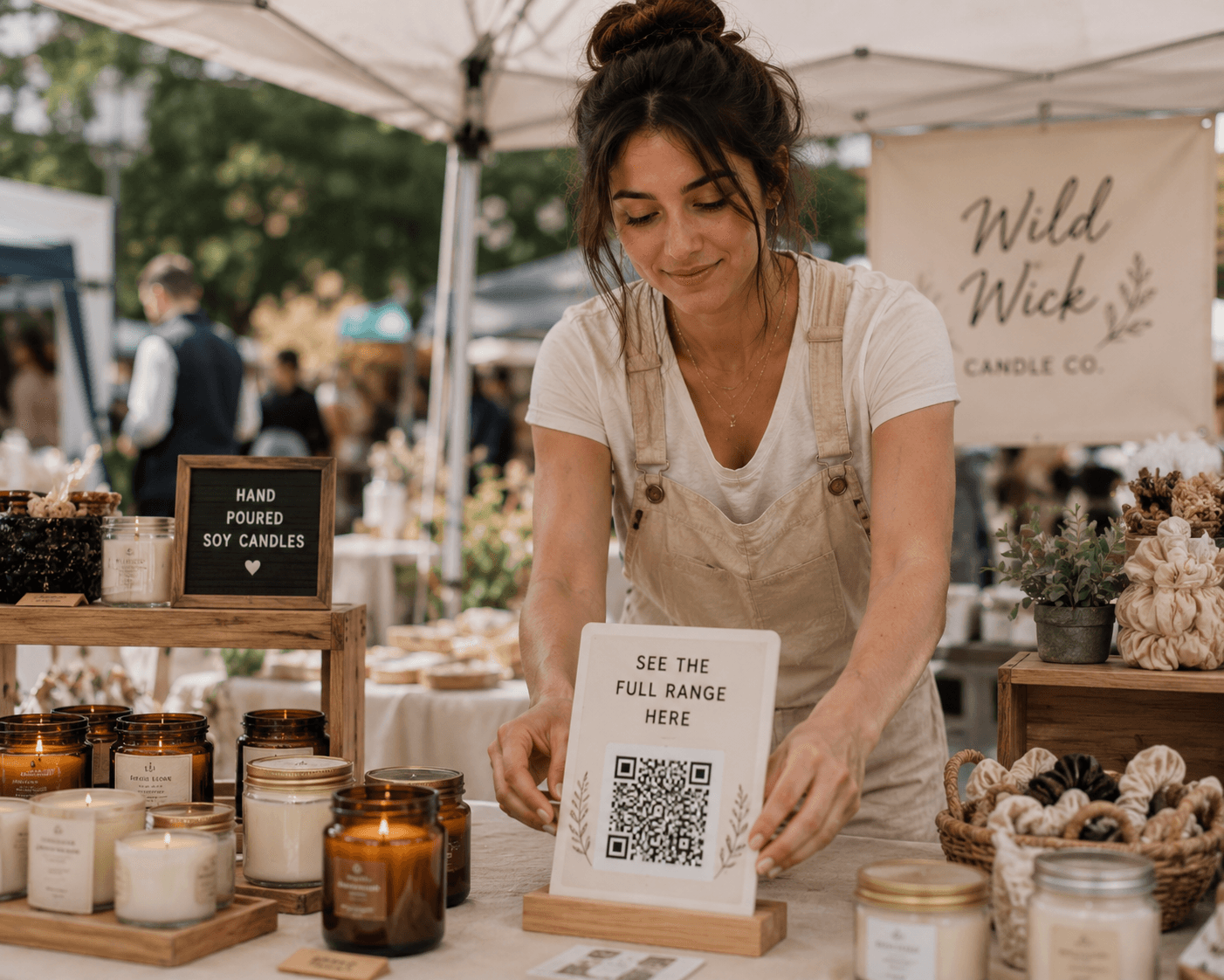 Market stall selling hand poured soy candles with a QR code sign